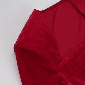 Close-up of the elegant neckline and sewing details on red velvet evening dress