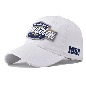 Close-up of vintage white cotton baseball cap with blue embroidery and distressed brim detail