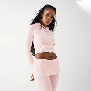 Detailed shot of pink knitted cropped hoodie and mini skirt set on fashion model