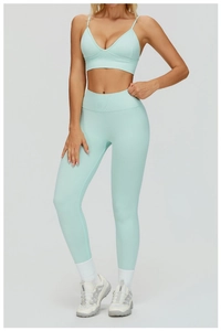Detail of high-waisted mint green seamless yoga leggings with ribbed texture and V-waist