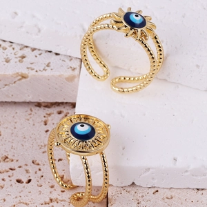 Detailed view of adjustable golden evil eye rings with blue enamel and rope textured bands