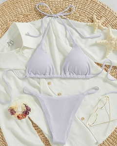 Flat lay of lilac ribbed halter bikini set with starfish and beach vacation accessories