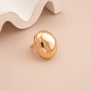Macro detail of large gold oval dome ring with a high-polished metallic mirror finish