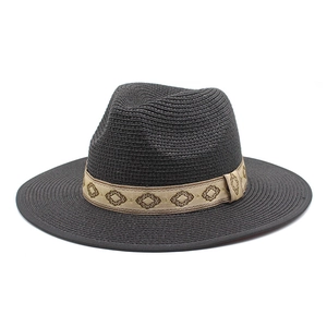Close-up of a dark woven Fedora hat featuring a decorative ethnic diamond pattern band