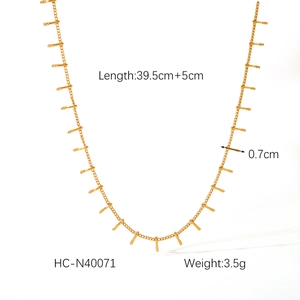 Detail of a thin gold-plated necklace featuring vertical rectangular pendant drops