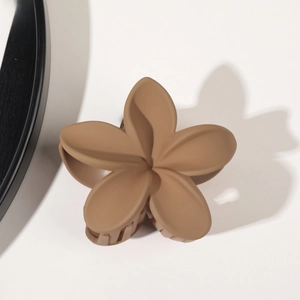 Detail view of the matte brown flower-shaped resin hair claw clip with frosted texture