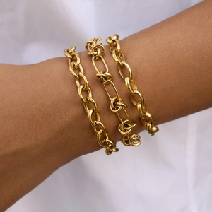 Detailed view of three-piece 18k gold plated stainless steel chain bracelets on a wrist