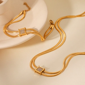 Close-up of golden double-layer snake chain with square zircon-encrusted pendant