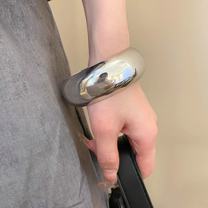 Gros plan d'un bracelet jonc argenté minimaliste avec une finition métallique lisse
