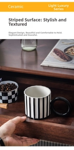 Detailed view of ceramic mug with black and white vertical stripes and round handle