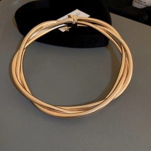 Detailed view of multilayer twisted rope chain necklace in a polished golden metallic finish