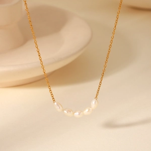 Macro detail of five freshwater pearls on a 18K gold-plated stainless steel chain