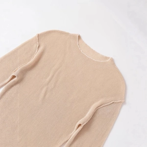 Beige ribbed knit sweater with mock neck and exposed shoulder seams on marble background