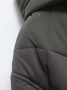 Detailed close-up of heavy-duty stitching and windproof fabric on hooded puffer jacket