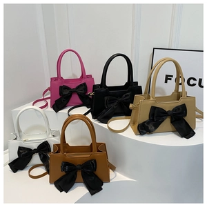 Group view of bow-knot handbags in five colors displayed on white multi-level steps
