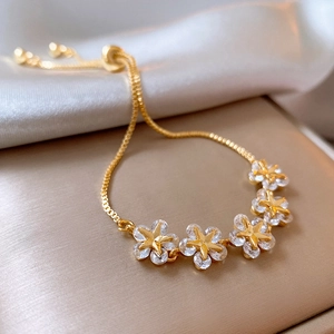 Detailed macro view of gold plated star flower bracelet with sparkling zircon stones