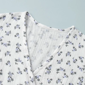 Detail of V-neckline on floral cotton dress showing textured fabric and size S label