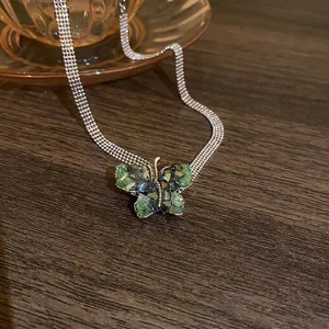 Elegant butterfly pendant necklace with dark green crystals on multi-strand silver chains