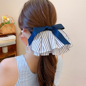 Detailansicht eines eleganten, großen blau gestreiften Haarschleifens am Pferdeschwanz