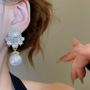Close-up of pearl drop earring with rhinestones on model showing jewelry luster