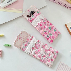 Detailed shot of quilted floral eyeglass pouches with lace trim and snap buttons