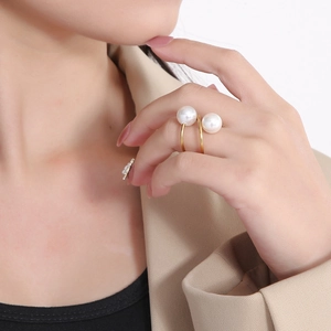 Detailed close-up of a gold spiral open ring featuring two elegant white pearls