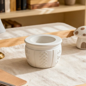 White ceramic storage bowl with Arabic relief pattern on cotton linen tablecloth