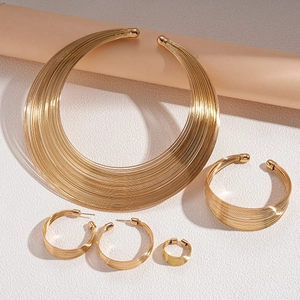 Detailed set of gold geometric multi-layer metal necklaces, bracelet, earrings, and ring