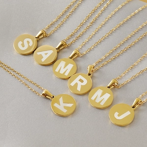 Detail of six 18K gold plated stainless steel initial necklaces with white letter charms