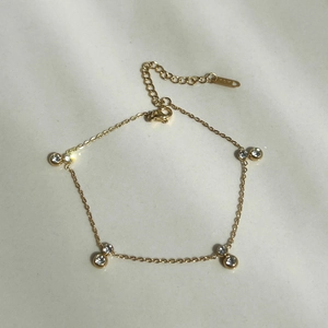 Detail of 18k gold plated bracelet featuring double zircon accents and lobster clasp