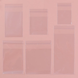 Transparent self-adhesive packaging bags for cookies and snacks on a pink background