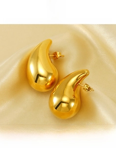 Macro shot of 18K gold plated hollow teardrop earrings on elegant silk fabric