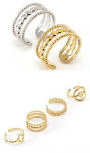 Detailed macro view of gold and silver four-leaf clover adjustable stainless steel rings