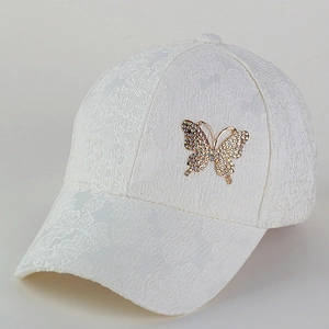 Close-up of white lace baseball cap with sparkling crystal butterfly ornament
