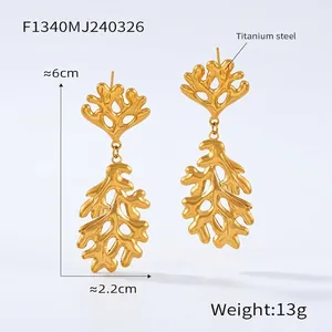 Detail of 6cm golden titanium steel earrings with organic branch texture and 13g weight