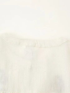 Detail of neckline stitching and natural linen fabric texture on a beige bohemian blouse