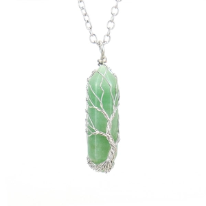 Detail of life tree wire wrapped design around a green hexagonal crystal column pendant
