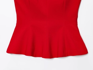 Detailed close-up of the red peplum hem with smooth fabric texture on this women top