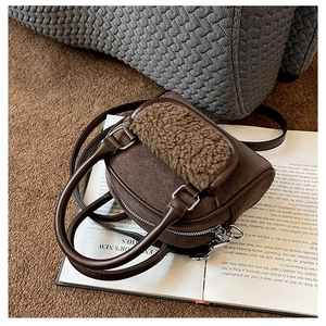 Detailed view of plush and brown PU leather handbag texture on a vintage book
