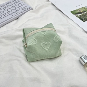 Détail de la trousse de maquillage vert menthe avec motifs cœurs et fermeture éclair
