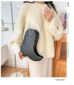 Vue détaillée d'un sac bandoulière noir en forme de botte avec broderie d'étoile.