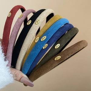 Détail de la texture en velours et du médaillon doré Love sur les bandeaux multicolores