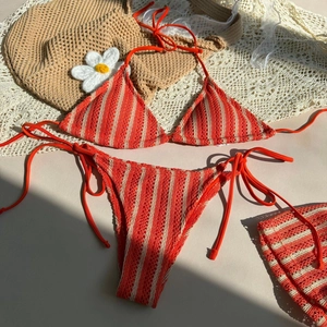 Detailed close-up of orange striped crochet bikini set with hollow knit texture