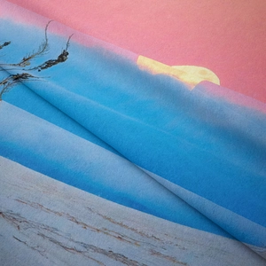 Detailed macro view of bohemian wall tapestry fabric showing soft gradient ocean sunset print