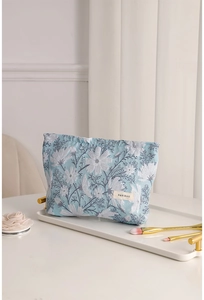 Pochette trucchi in jacquard floreale azzurro con pennelli su un vassoio elegante