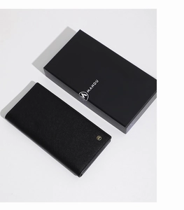 Saffiano leather long wallet in black with golden logo next to branded gift packaging