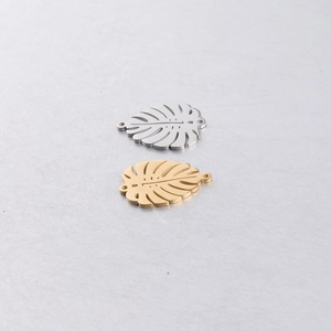 Detailed view of monstera leaf charms in gold and silver finish for DIY jewelry