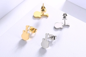 Detailed view of guitar-shaped stainless steel stud earrings in gold and silver finishes