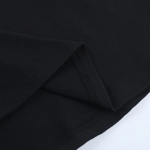 Detailed close-up of double-needle stitching and black knit fabric texture on the dress