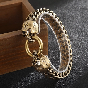 Detailed close-up of punk skull clasp and heavy woven steel chain link on a male bracelet
